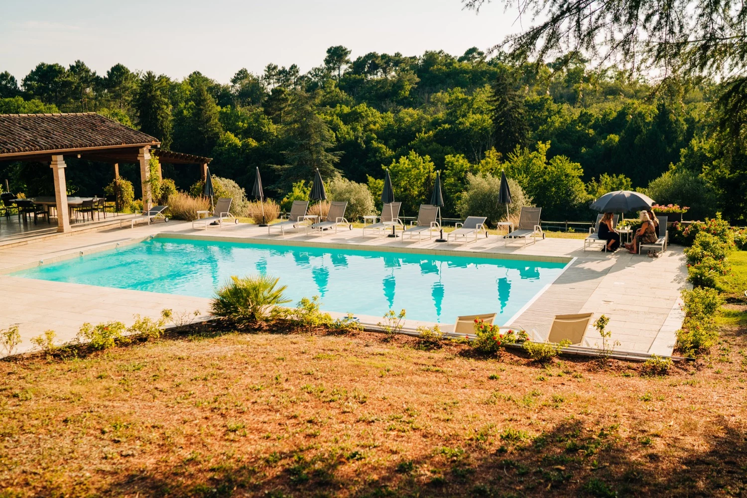 An outdoor pool surrounded by beautiful nature in France at Domaine La Fauconnie, photo captured by Magic Wedding Photographer in Europe.
